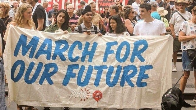 AYCC members hold up a sign at a climate change March