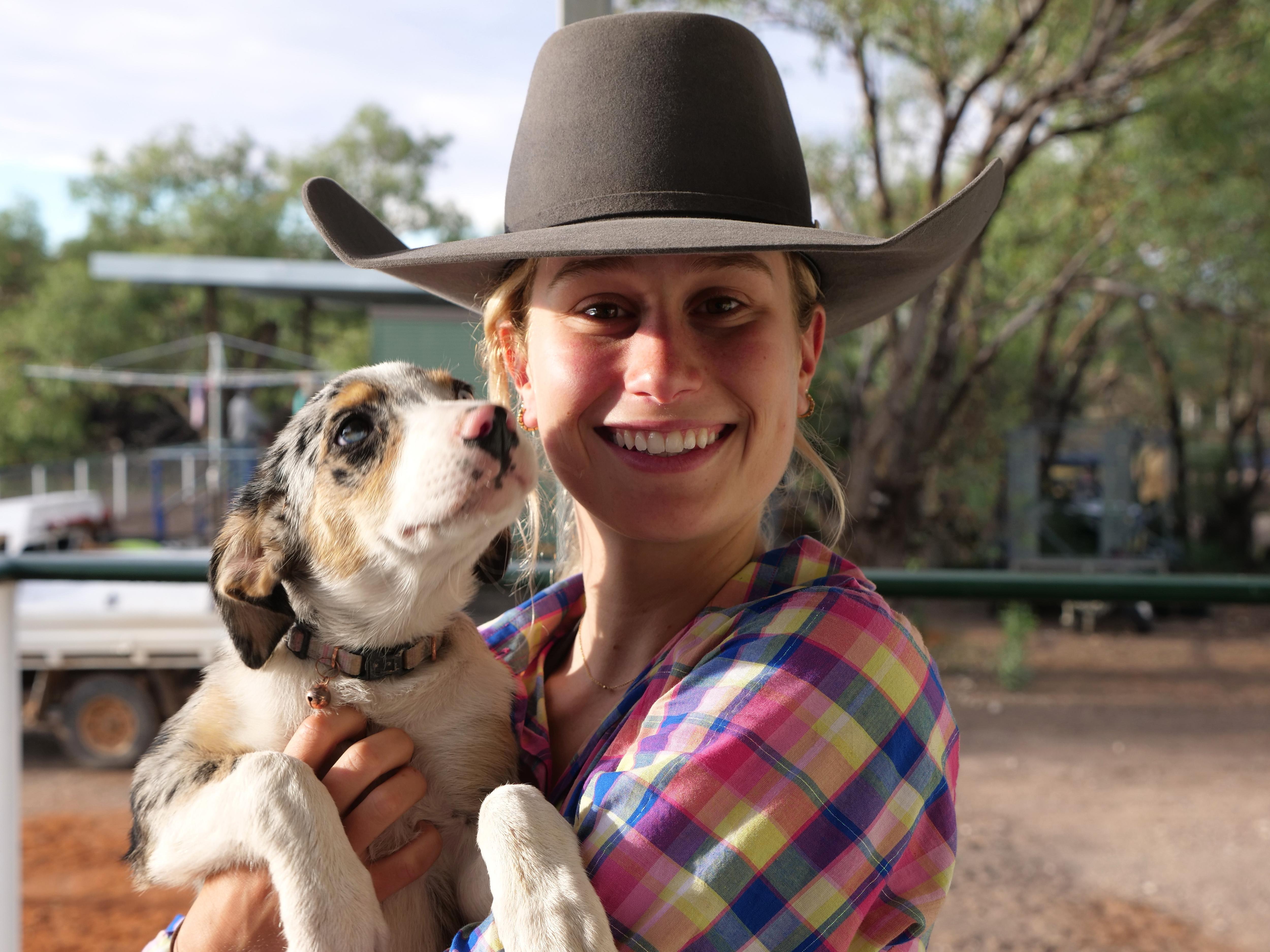 Sophie Bruce sorrindo segurando um cachorrinho. 