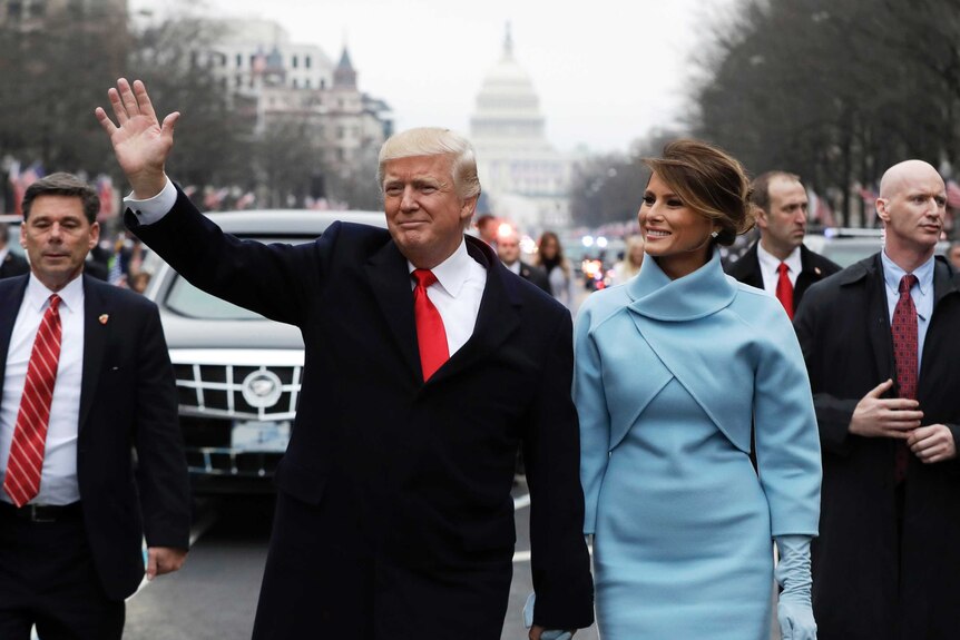 Donald and Melania Trump walk during the inaugural parade.