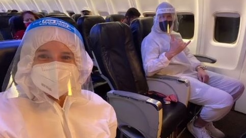 Two people sit on a plane in full PPE, in a screenshot from a Neroli Meadows Instagram story.