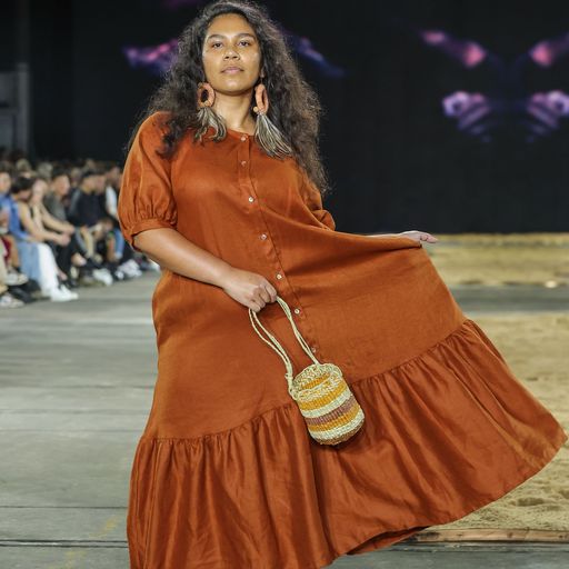A woman in an orange dress carrying a bag