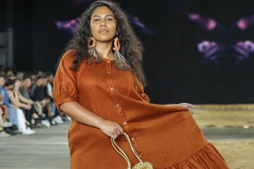 A woman in an orange dress carrying a bag