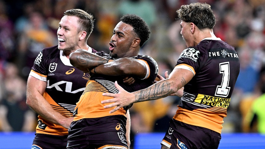 Three Brisbane Broncos NRL players celebrate a try.