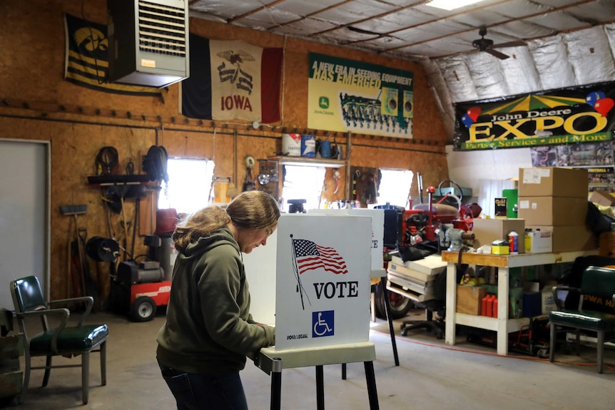 A polling station is set up in a garage full of machinery and tools.