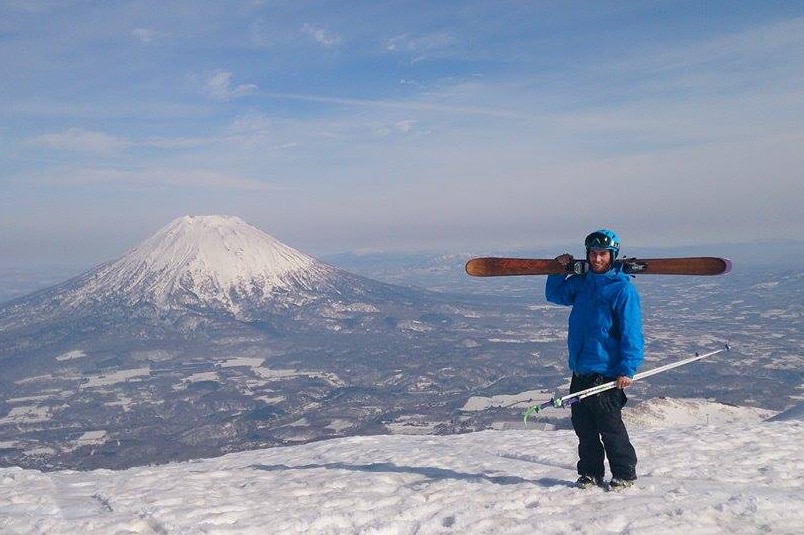 A man standing on top of a ski slope in Japan.