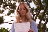 Hunter Reynolds holds an infringement notice in her hands.