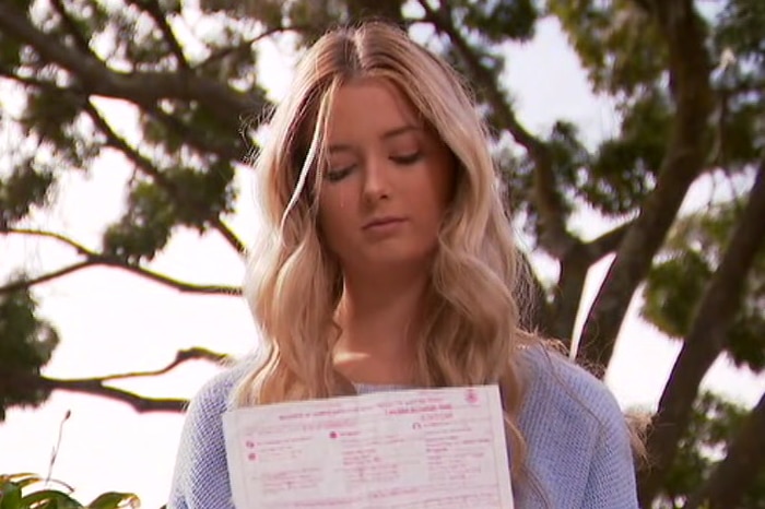 Hunter Reynolds holds an infringement notice in her hands.