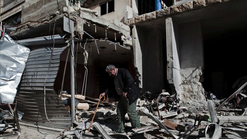 An elderly resident inspects his home in Aleppo