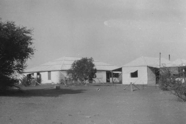 A black and white photo of a homestead on a cattle station.