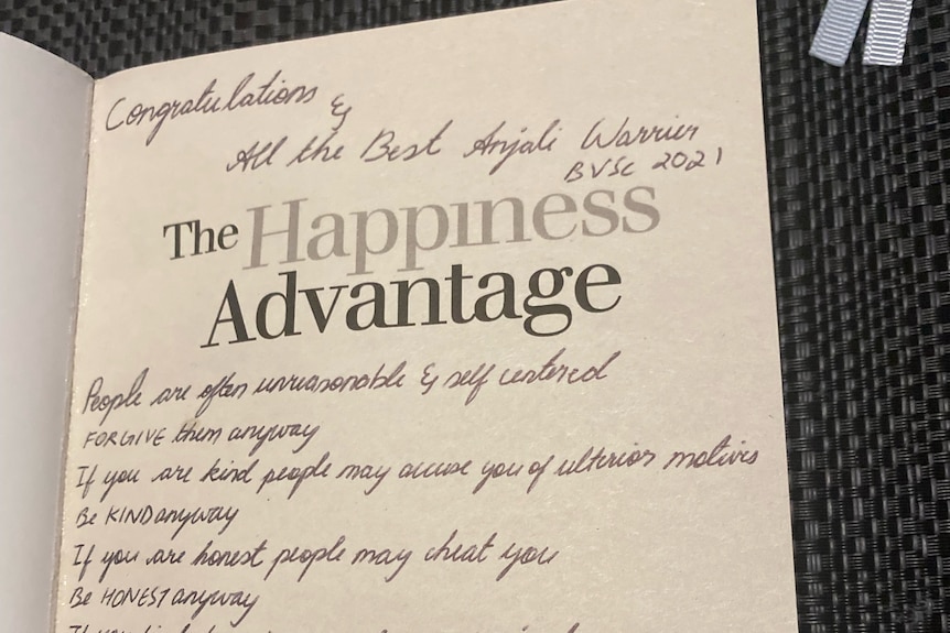 An image of The Happiness Advantage book with a handwritten note in the first page