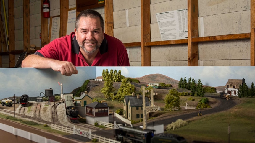 Col Bartley stands next to his model trains.