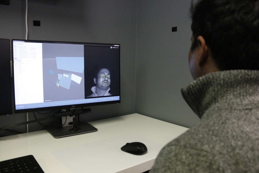 Man looking at a screen with a camera. It is able to detect where his eyes are looking.