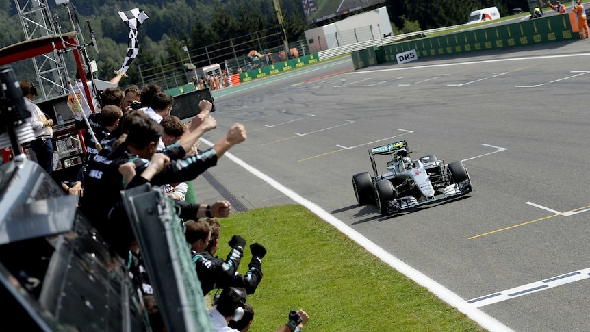 Team members cheer as Mercedes driver Nico Rosberg wins Belgian F1 Grand Prix at Spa-Francorchamps.