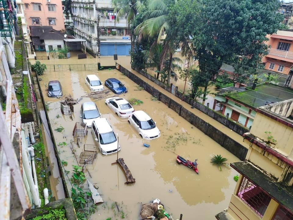 A view from several storeys up looks onto a flooded carpark where several cars are underwater