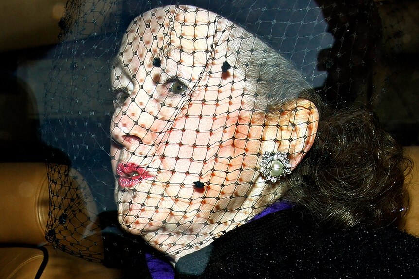 A woman with black netting over her face 
