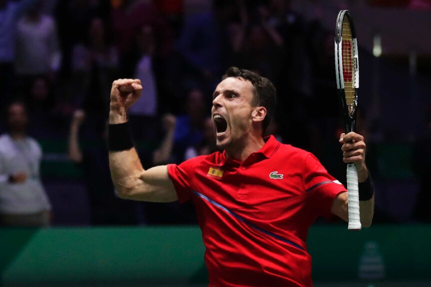 Roberto Bautusta Agut celebrates with a scream and by clenching his fists