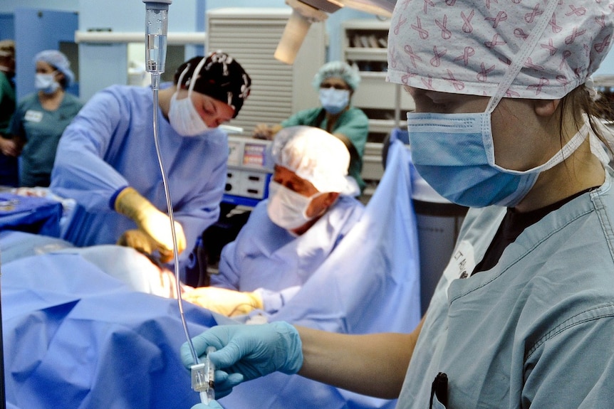 Nurses and doctor pictured during medical procedure, generic image.