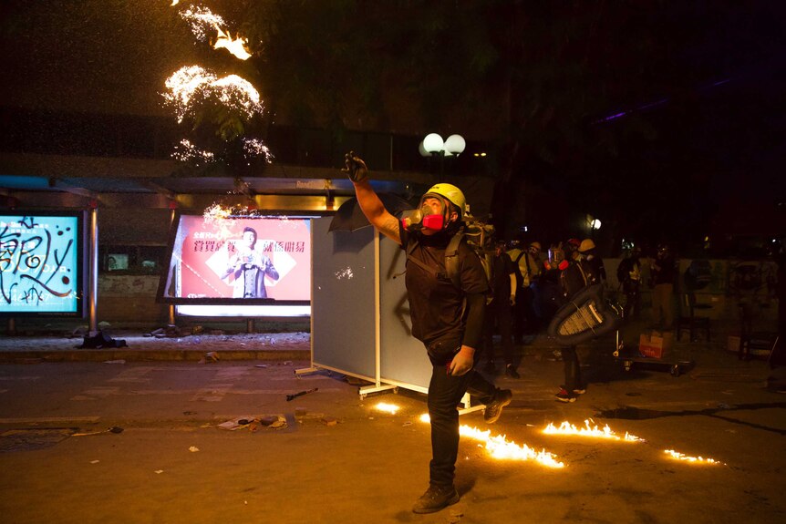 A protester throws a molotov cocktail at police near the Hong Kong Polytechnic University in Hong Kong.