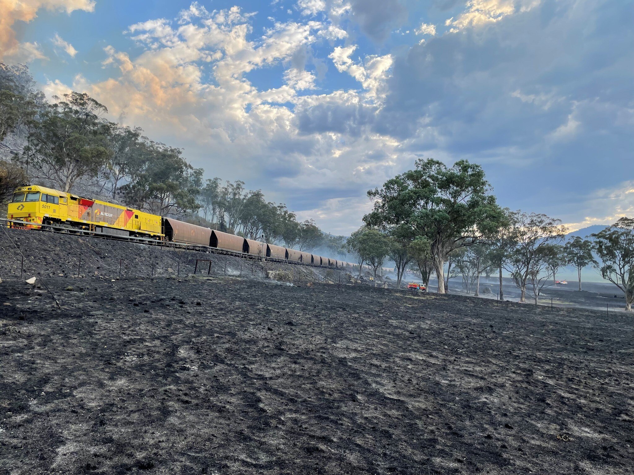 A train next to a burnt paddock