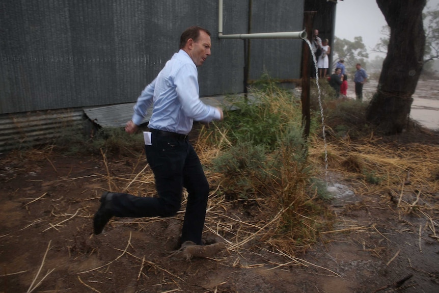 Tony Abbott runs in the rain in Bourke