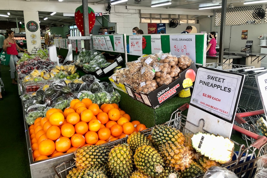 Pineapples and an array of fruit are in grocery shop