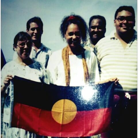 A group od Indigenous activists hold the Aboriginal flag