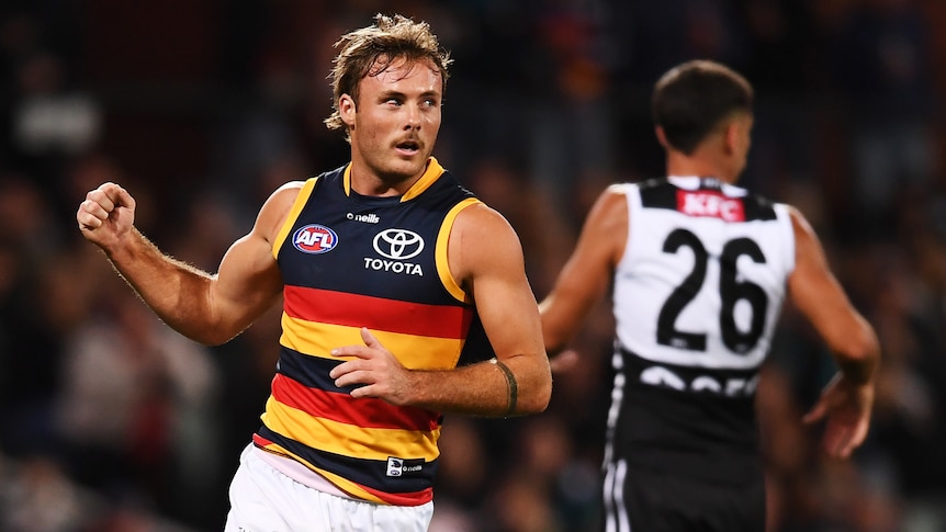 An Adelaide Crows AFL player pumps his right fist as he celebrates a goal.