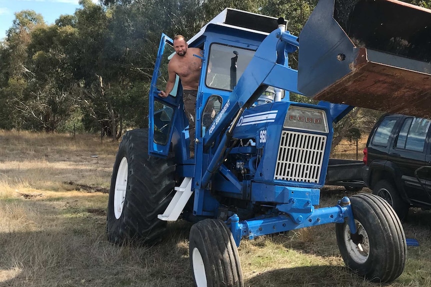 A shirtless man on a tractor.