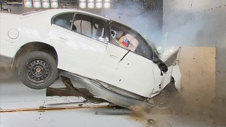 A white car involved in a test crash environment has a head-on collision.