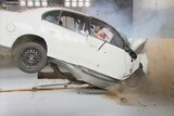 A white car involved in a test crash environment has a head-on collision.