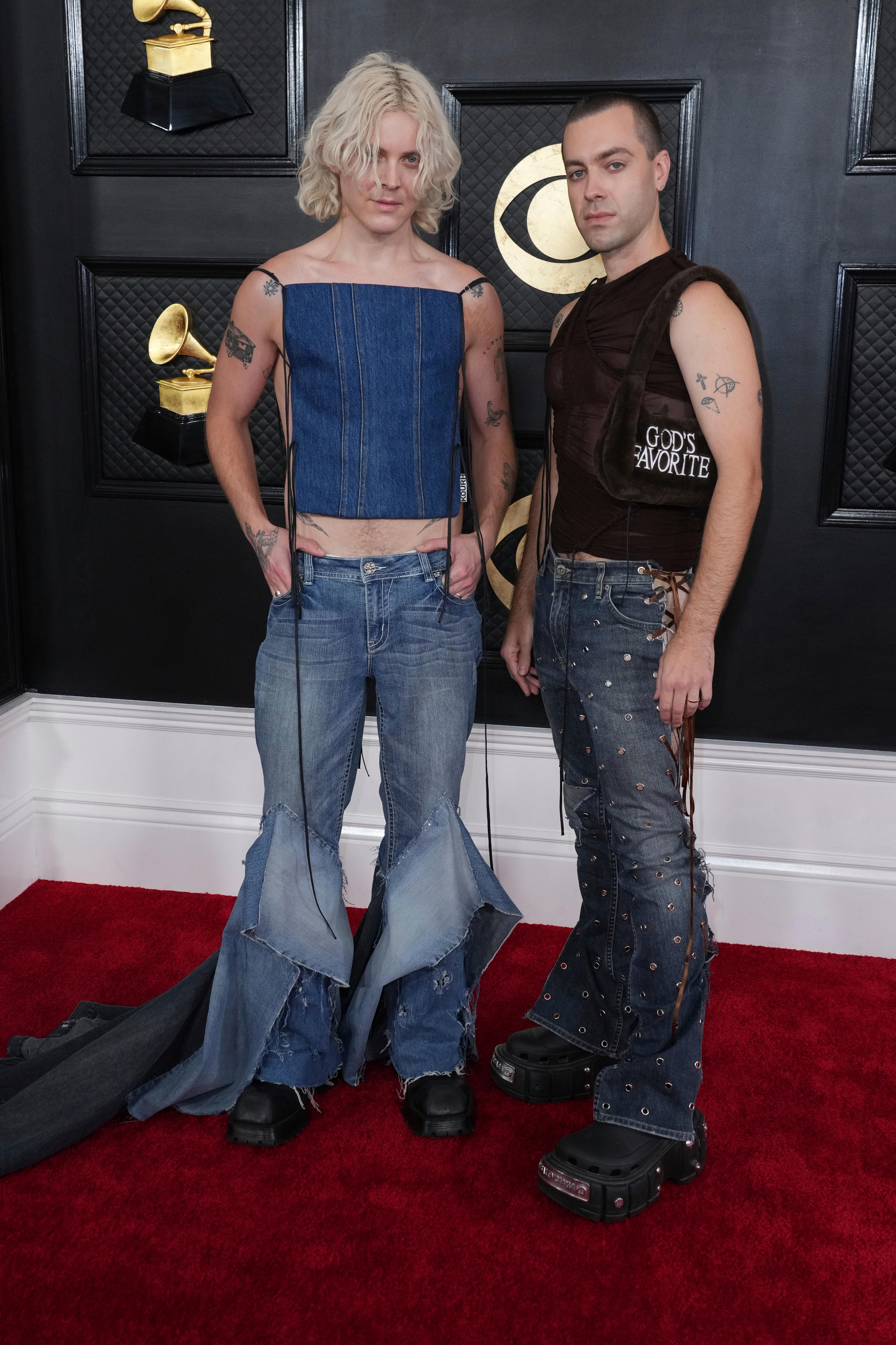 Tim Nelson, wearing flared jeans with a denim tie-up top, and Sam Netterfield wearing jeans with a dark brown vest