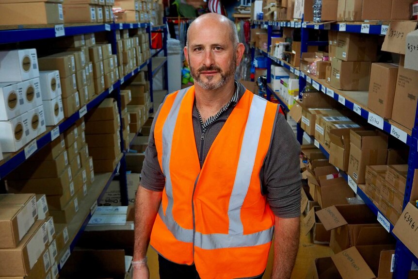 Farren Ostilly standing in an aisle of a warehouse