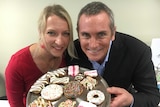 Emma and Russell Gibbons pose with a colourful plate of their dog biscuits that look just like human biscuits.