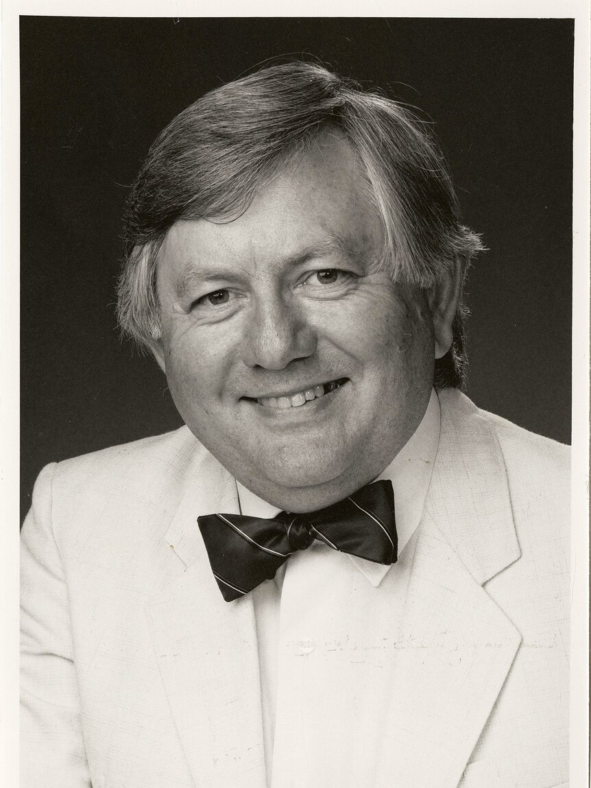 A black and white image of a man wearing a bow tie