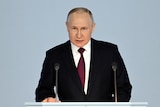Putin looks down the barrel of the camera, pulling a serious expression 