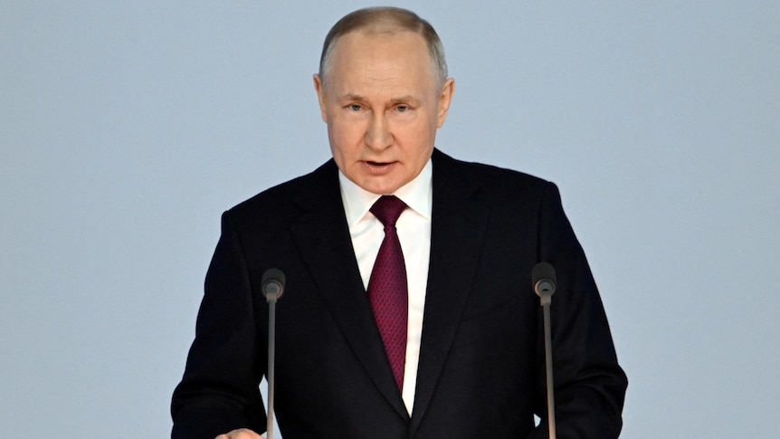 Putin looks down the barrel of the camera, pulling a serious expression 