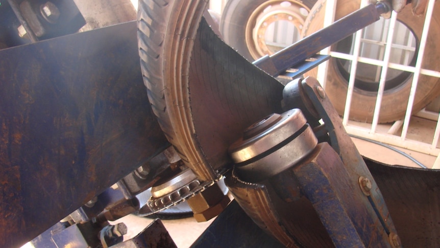 A tyre being cut in half by a machine