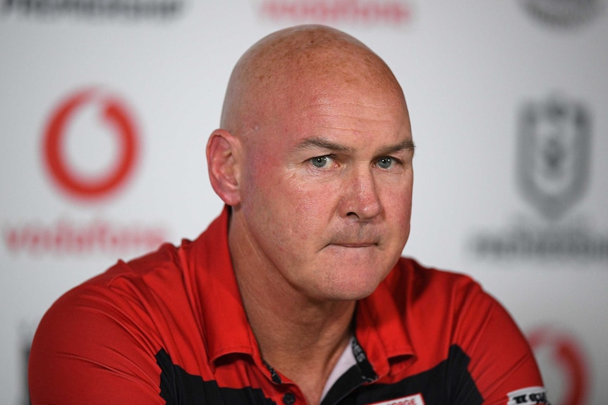 Paul McGregor wears a red polo shirt and purses his lips, looking off to one side