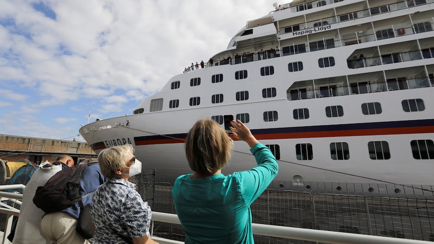 People welcome a cruise ship.