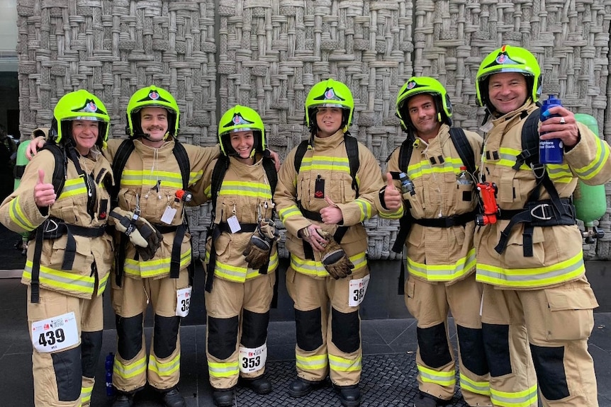 A group of firefighters lined up in uniform smiling