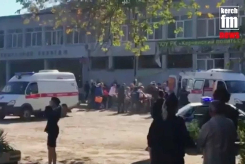 In this image made from video, emergency services load an injured person into an ambulance outside the college.