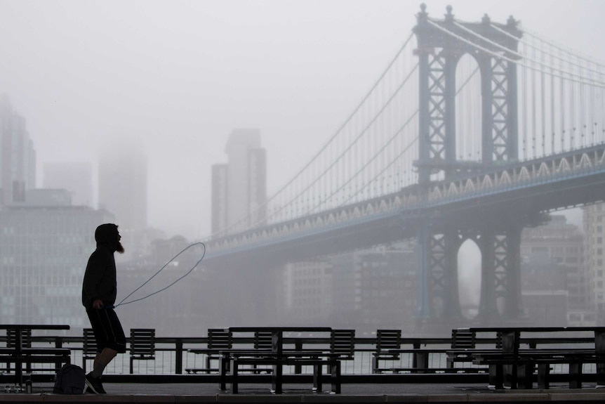 A man is framed by the Manhattan bridge as he exercises below the FDR drive in Lower Manhattan.