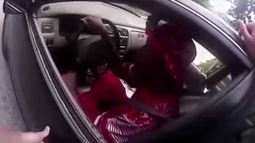 A policeman looks into Samuel DuBose's car