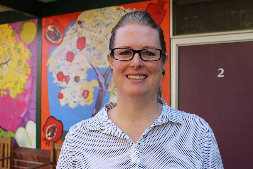 Caroline Verth photographed in front of mural.