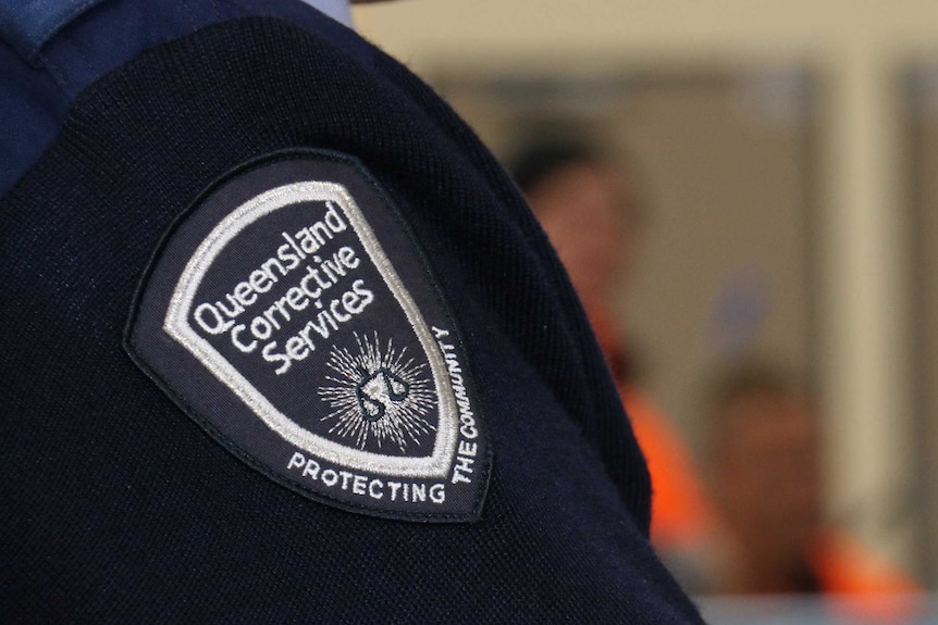 Close up of the Queensland Corrective Services logo on the patch on an officer's shoulder
