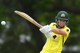 An Australian women's cricketer extends her arms as she plays a cross-bat shot in an ODI match. 