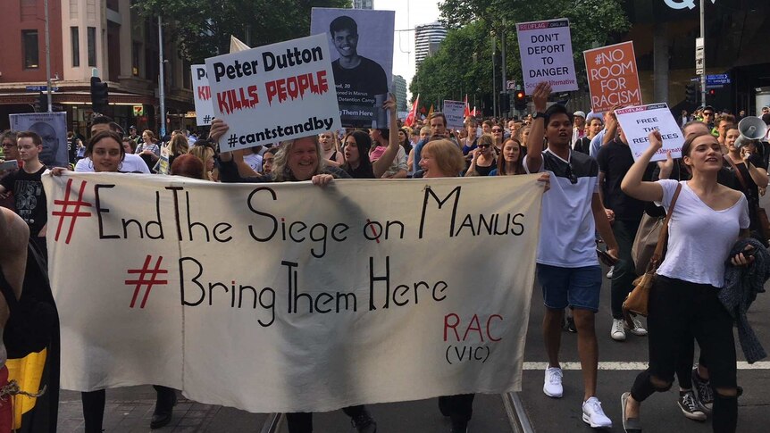 Protesters carrying signs march in central Melbourne against the Manus Island detention centre on 10 March 2017.