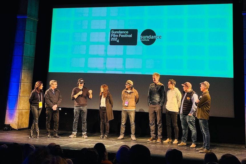Nine people standing on stage at Sundance Film Festival.