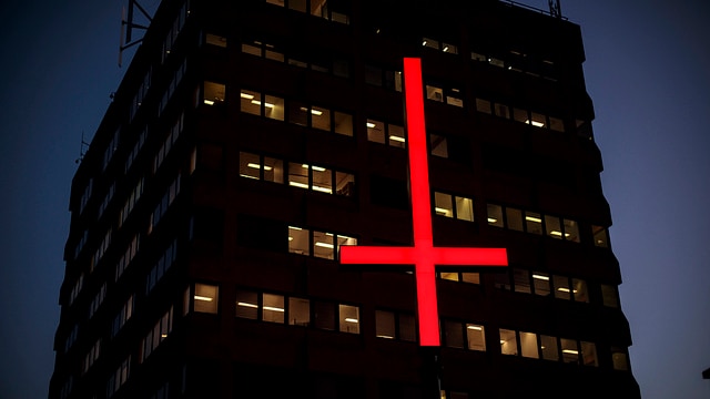 Picture of a red inverted cross outside a tall building