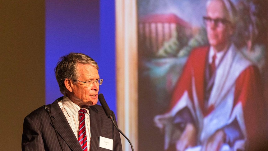 Rescue Churchie coordinator Dr Tom Biggs speaks in front of a portrait of former Churchie headmaster Harry Roberts